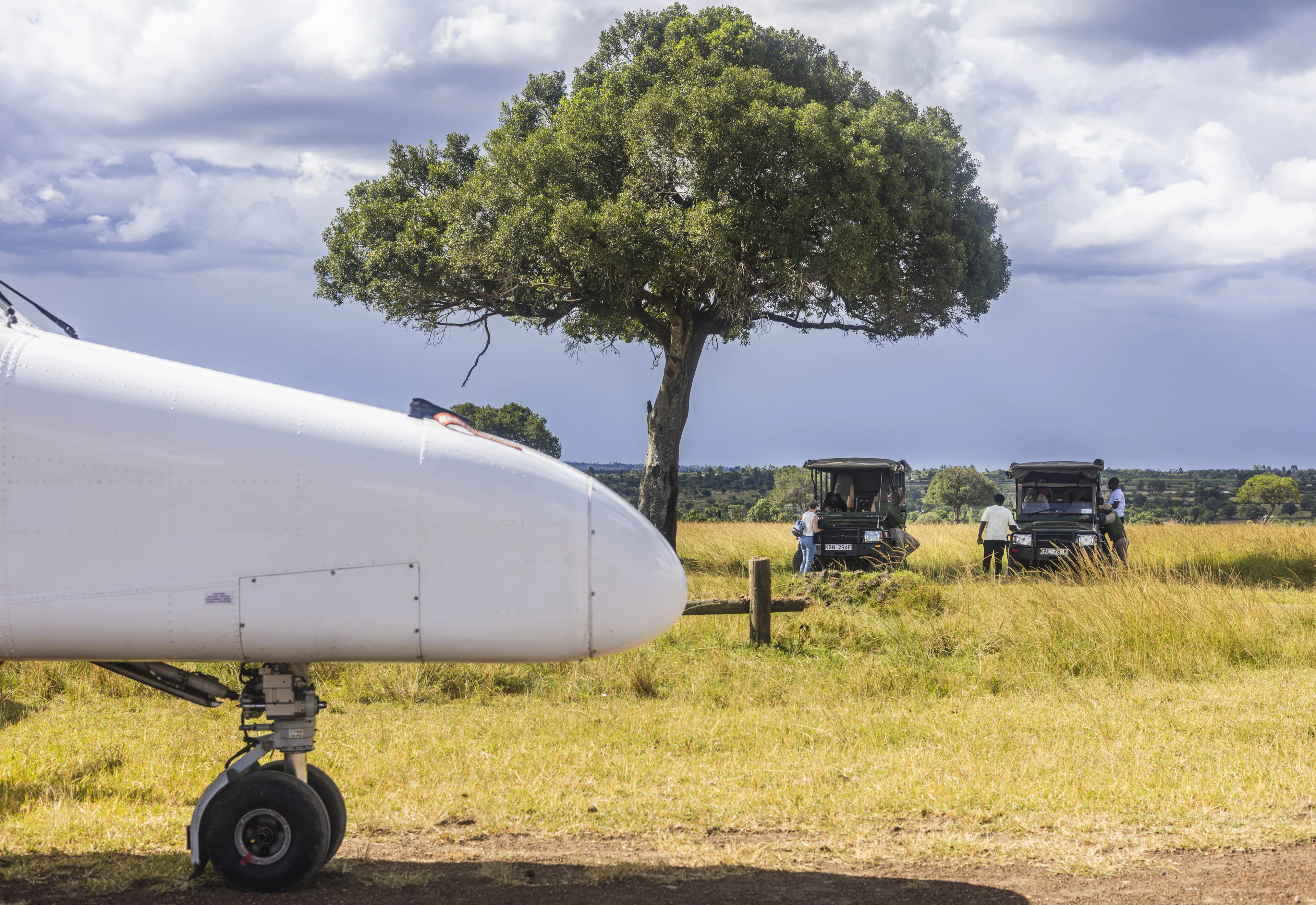 Safari vehicle waiting beside bush airstrip as Kasas aircraft arrives