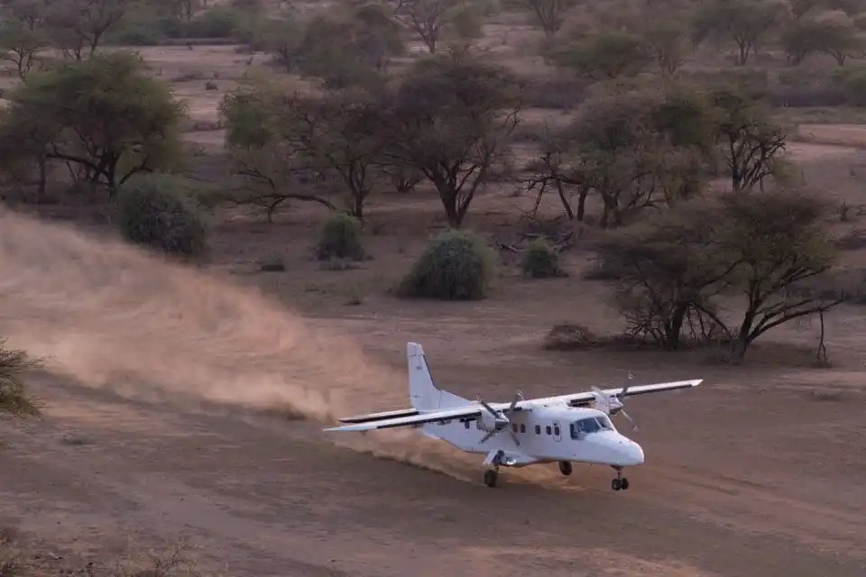 Dornier 228 taking off from short unpaved bush airstrip